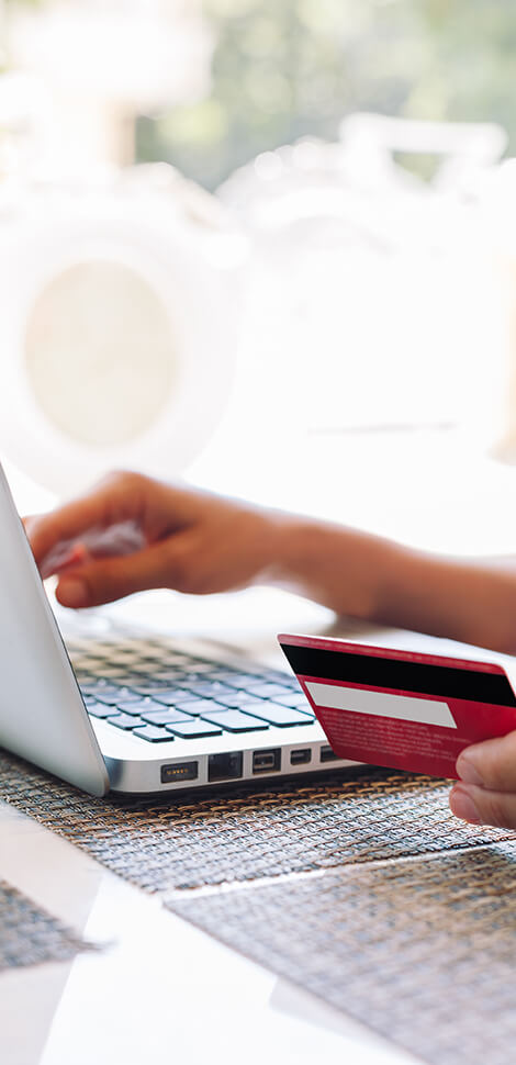 hand typing credit card number into laptop