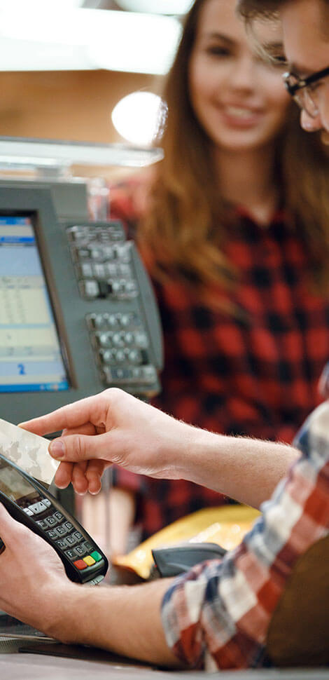 Man paying cashier with debit card machine
